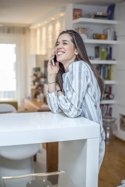 Mujer joven con teléfono en casa — Foto de Stock