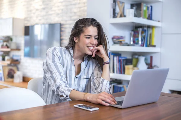 Jonge vrouw werkt op laptop thuis — Stockfoto