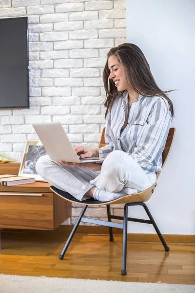 Jonge vrouw werkt op laptop thuis — Stockfoto