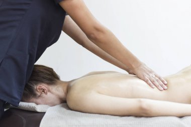 Spa salonunda masaj yaptıran bir kadın.