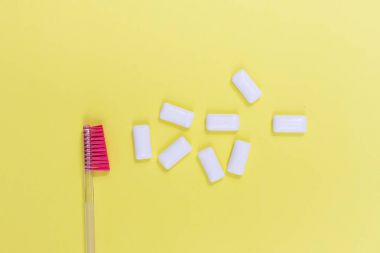 Toothbrush with chewing gum isolated on yellow background clipart