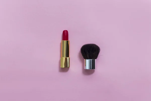 Oversikt over sminkesettet: rød leppestift og sminkebørste på pastell – stockfoto