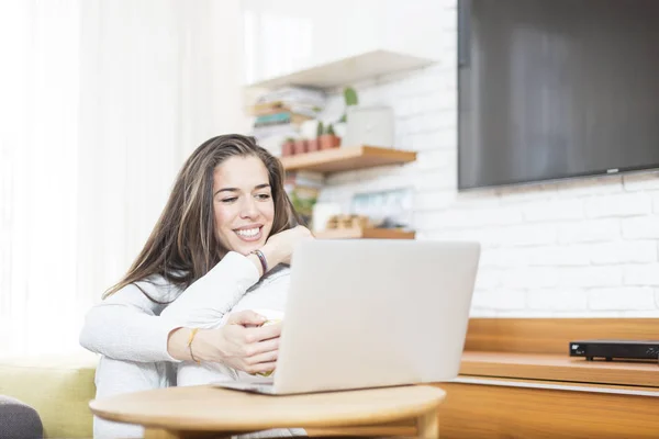 Mooie jongedame zittend op de vloer die op laptop werkt. Mo — Stockfoto