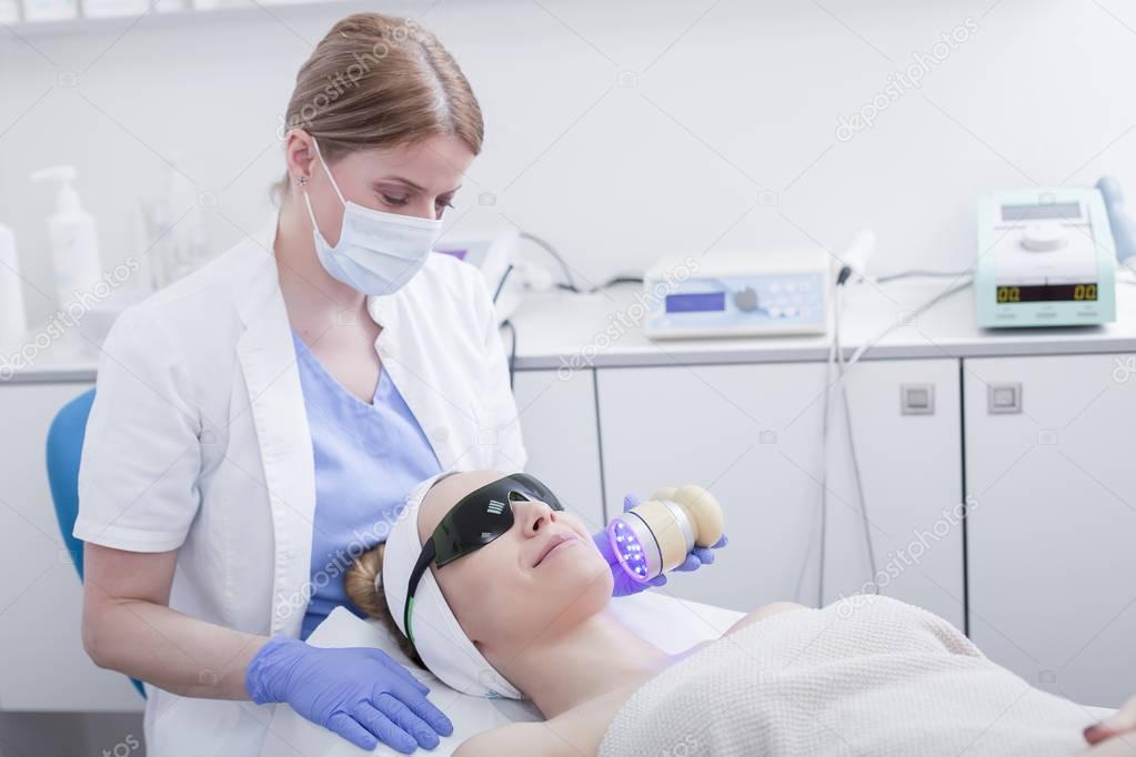 Woman getting facial laser treatment