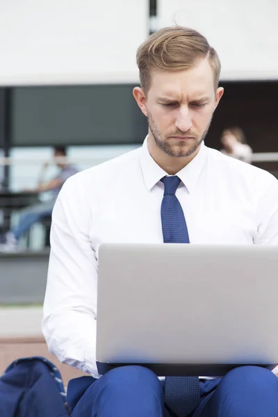 Bonito jovem empresário trabalhando no laptop — Fotografia de Stock