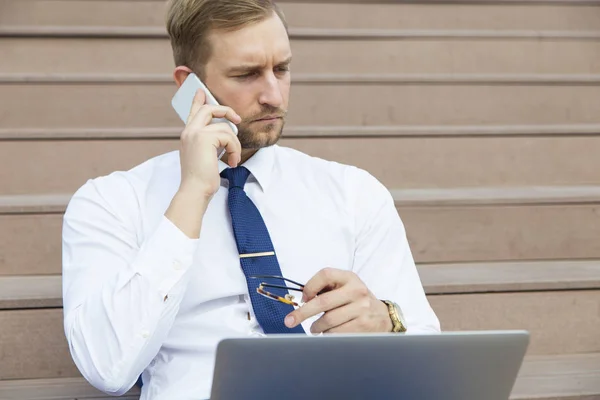 Knappe jonge zakenman die op laptop werkt — Stockfoto