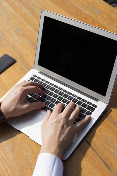 Close-up of man typing on laptop
