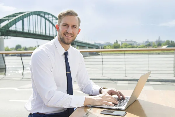 Pohledný mladý podnikatel pracuje na notebooku — Stock fotografie