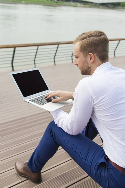 Pohledný mladý podnikatel pracuje na notebooku — Stock fotografie