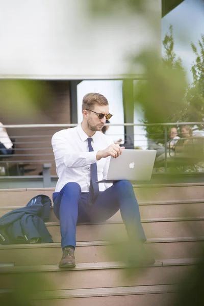 Pohledný mladý podnikatel pracuje na notebooku — Stock fotografie