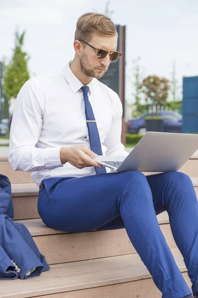 Pohledný mladý podnikatel pracuje na notebooku — Stock fotografie