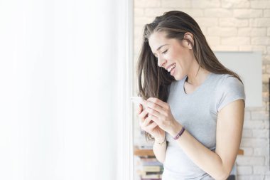 Sabah sahne. Rüzgar yanındaki cep telefonu kullanan güzel kadın