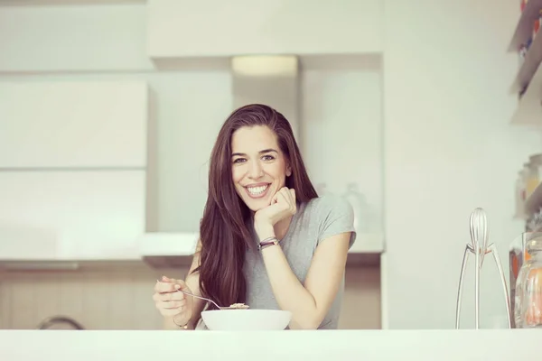 Красива молода жінка сніданок крупи на кухні — стокове фото