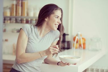 Güzel ve genç birbayan kahvaltılık tahıllar mutfakta