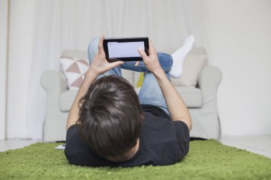 Genç odasında bir tablet ile sıçrayan ve sörf 