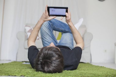 Genç odasında bir tablet ile sıçrayan ve sörf 