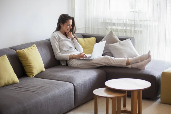 Jonge vrouw in woonkamer — Stockfoto