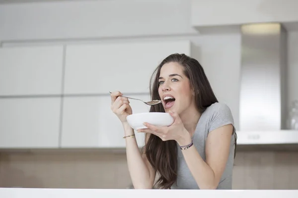 Schöne junge Frau frühstückt — Stockfoto