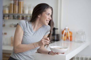 Güzel ve genç birbayan kahvaltılık tahıllar mutfakta