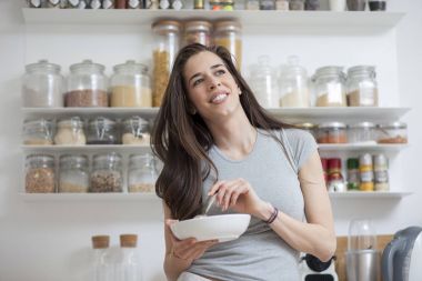 Güzel ve genç birbayan kahvaltılık tahıllar mutfakta