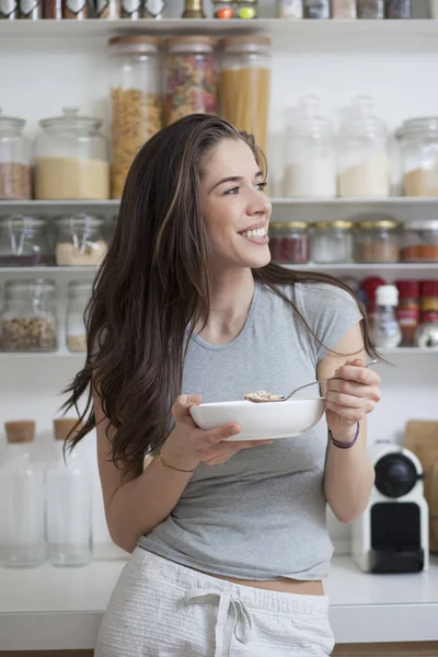 Güzel ve genç birbayan kahvaltılık tahıllar mutfakta