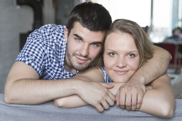 Lachende paar op de sofa in de woonkamer — Stockfoto