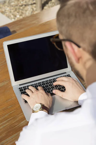 Красивий бізнесмен працює на ноутбуці на відкритому повітрі — стокове фото