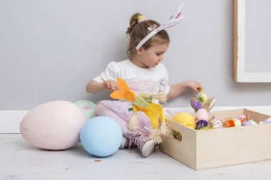 Paskalya yumurtaları ve bir tavşan bebek oynayan kız