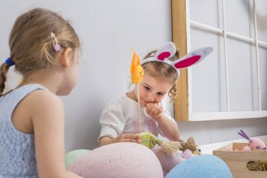 Paskalya yumurtaları ve bir tavşan bebek ile oynayan çocuklar
