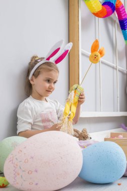 Paskalya yumurtaları ve bir tavşan bebek oynayan kız