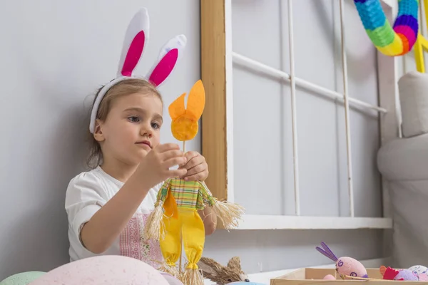 Chica jugando con los huevos de Pascua y una muñeca de conejo —  Fotos de Stock