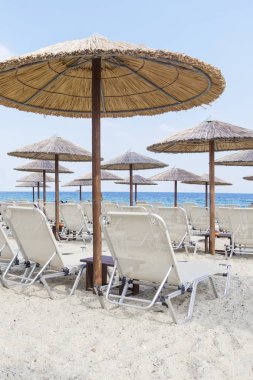 Güneş şemsiyesi ve tropik sahil şeridi üzerinde plaj yataklar