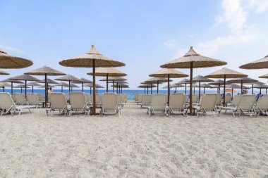 Güneş şemsiyesi ve tropik sahil şeridi üzerinde plaj yataklar