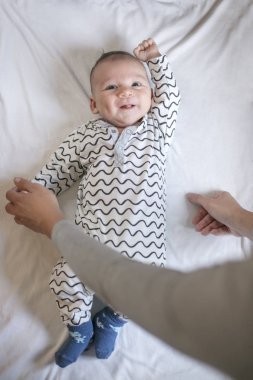 Annenin elleri ile onun yatakta yeni doğmuş çocuk