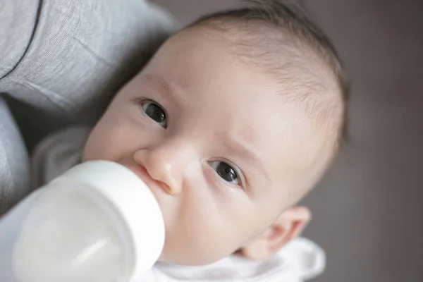 Мать кормит новорожденного ребенка из бутылки — стоковое фото