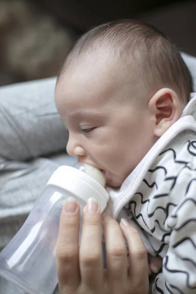 Мать кормит новорожденного ребенка из бутылки — стоковое фото
