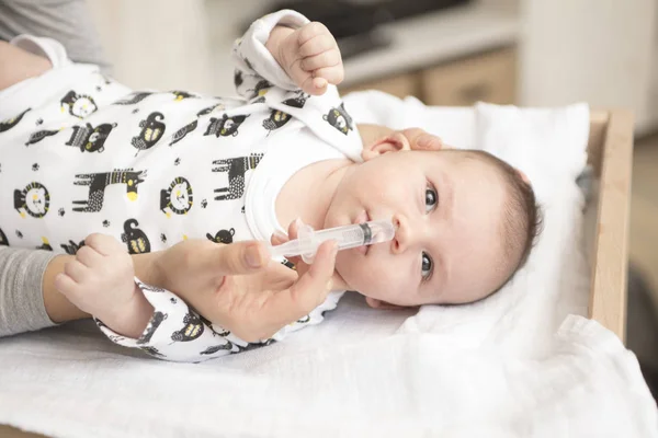 Anya takarít a baba orrát a fecskendővel — Stock Fotó