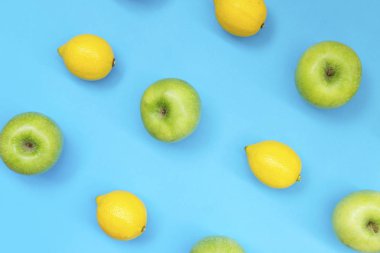 Mavi arka plan üzerinde renkli meyve desen taze limon ve elma Üstten Görünüm