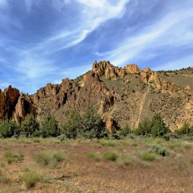Jagged Smith Rocks and swirling clouds clipart