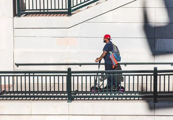 Denver, Colorado / ABD - 8 Ekim 2019 Denver şehir merkezinde bir adam scooter kullanıyor..