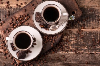 Ahşap arka planda kavrulmuş fasulyeli kahve fincanı.