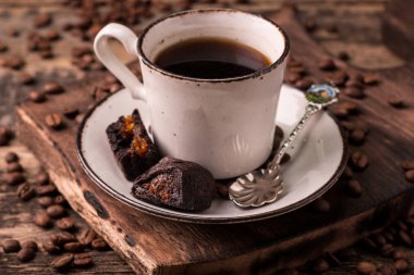 Ahşap arka planda kavrulmuş fasulyeli kahve fincanı.