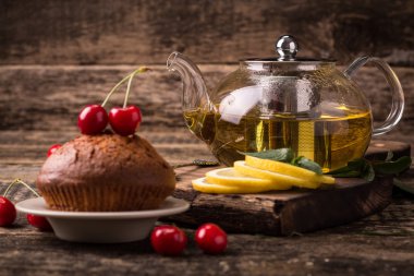 Sıcak cam çaydanlık ve bardak çay kaşığı ile ve ahşap masa Buhar 