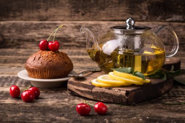 Sıcak cam çaydanlık ve bardak çay kaşığı ile ve ahşap masa Buhar 