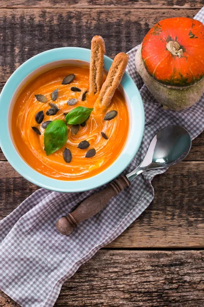 Roasted pumpkin and carrot soup with cream and pumpkin seeds