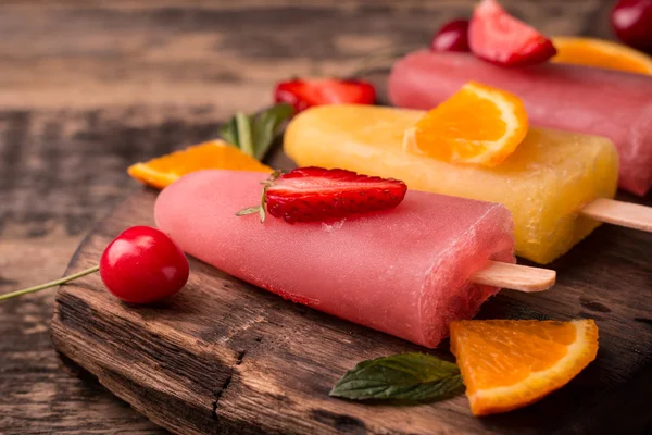 Refrescantes paletas de paletas de frutas en la mesa de madera con bayas y frutas —  Fotos de Stock