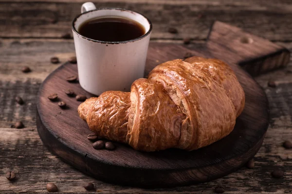 Frukost med kaffe och croissanter på vintage träbord — Stockfoto