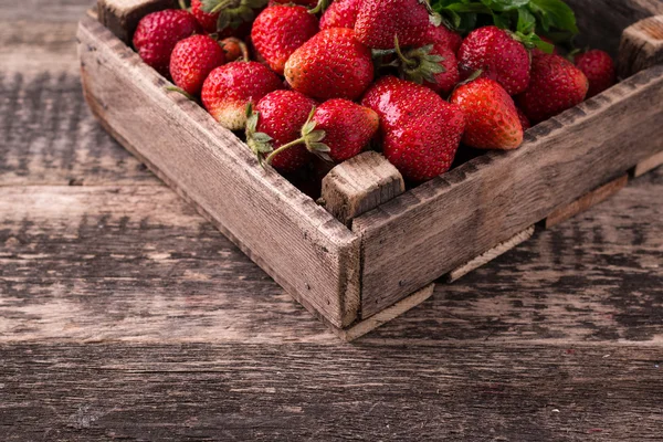 Fresas frescas en la caja sobre mesa vintage de madera — Foto de Stock