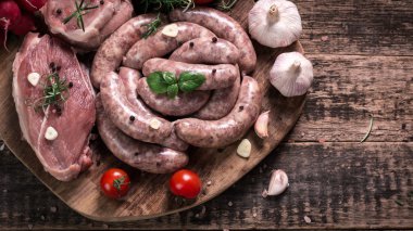 Taze kasap et ürün yelpazesine ahşap masa üzerinde taze biberiye ile süslenmiş kesmek