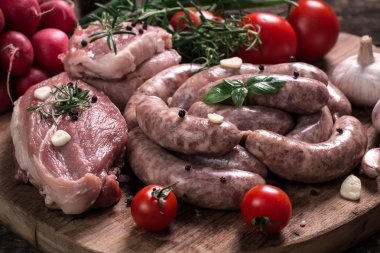 Taze kasap et ürün yelpazesine ahşap masa üzerinde taze biberiye ile süslenmiş kesmek